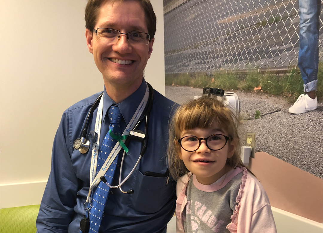 A doctor smiles along with a young CDG patient